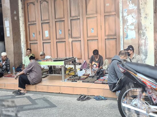 An einer Straße in Mataram sitzen  die Edelsteinhändler. Große Ringe mit Steinen werden hier getauscht und gehandelt. Hier tragen nicht die Frauen diese Ringe, sondern die Männer.