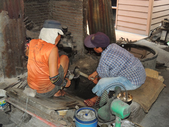 Hier wird von Hand abwechselnd auf dem erhitzten Klumpen gehämmert.