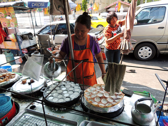 Seeehr lecker ist auch diese warme Süßspeise "Kanom Krok" genannt.
Ein Teig aus gekochtem Reis, Kokosmilch, Kokosnuss und Zucker. Hat etwas Ähnlichkeit mit einer Mischung aus Milchreis und Pudding.