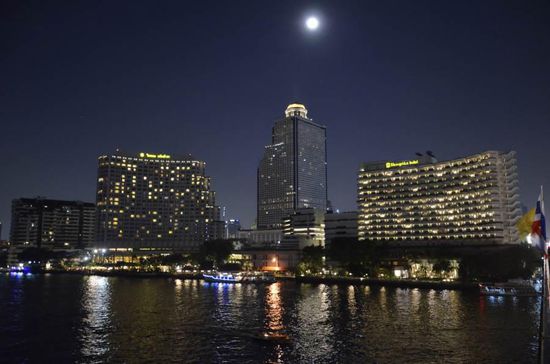 Blick vom Ibis-Garten auf den Fluss und die Skyline des Stadtviertels "Silom" mit dem State Tower in der Mitte