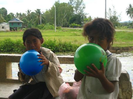 suesse Schulkinder beim Aufblasen der Luftballons