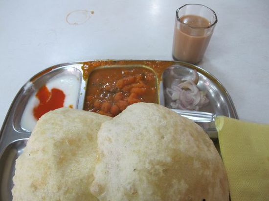 meine morgendliche Mahlzeit: Puri (herausfritiertes "Weissbrot") mit Kartoffelcurry, Jogurthdip, Zwiebel und natuerlich Chai (supersuesser Milchtee)