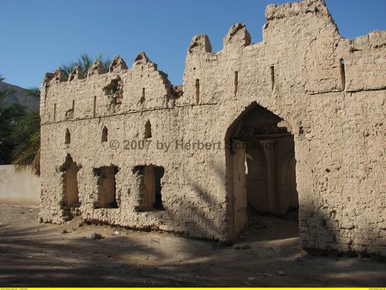 vorbei an alten verfallenden Lehmbauten