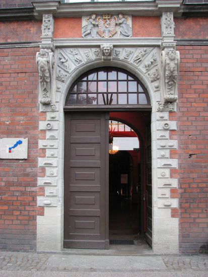 Das beachtenswerte Eingangsportal zeigt personifizierte Untugenden, die entweder Grimassen zeigen oder einfach nur lächeln.