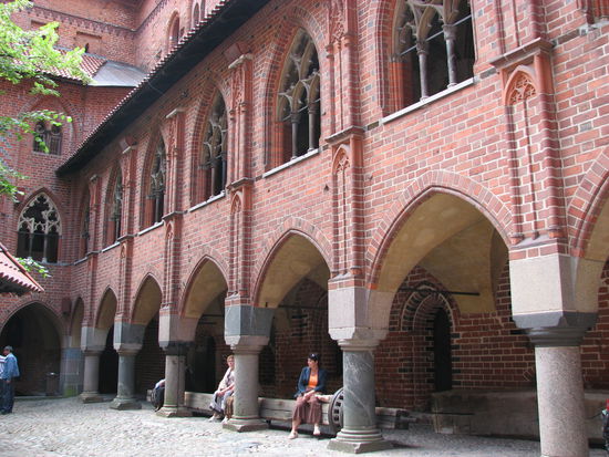 Innenhof der Hochburg mit Säulenarkaden und aufwändigen gotischen Fenster-Maßwerken