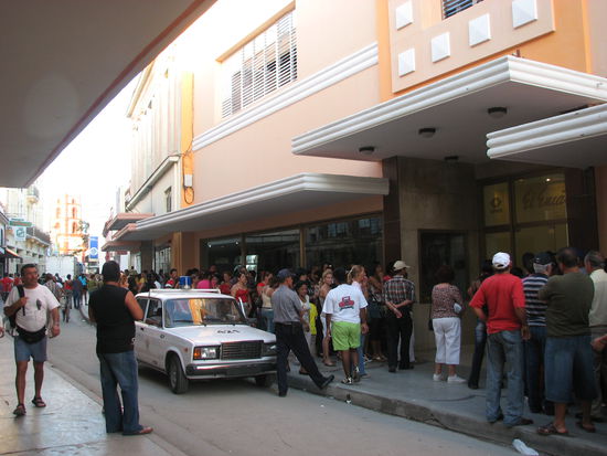Die Wiedereröffnung eines abgebrannten Kaufhauses verursacht ein Verkehrschaos. Obwohl nicht voll, werden die Besucher unter Polizeikontrolle nur zu kleinen Gruppen eingelassen.