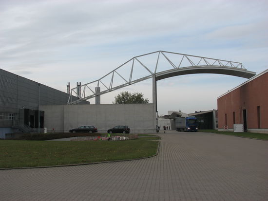 Die puristisch anmutende, ziegelsteinverkleidete Fabrikationshalle wurde vom portugiesischen Architekt Alvaro Siza gebaut, die er durch eine brückenartige Dachkonstruktion mit der benachbarten Halle verband.