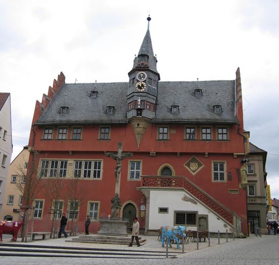 Neues Rathaus (1515) mit Lanzentürmchen, kunstvoller Figuren- bzw. Monduhr, Freitreppe mit spätgotischer Maßwerkbrüstung und Narrenhäuschen (früher Arrest- und Ausnüchterungszelle).