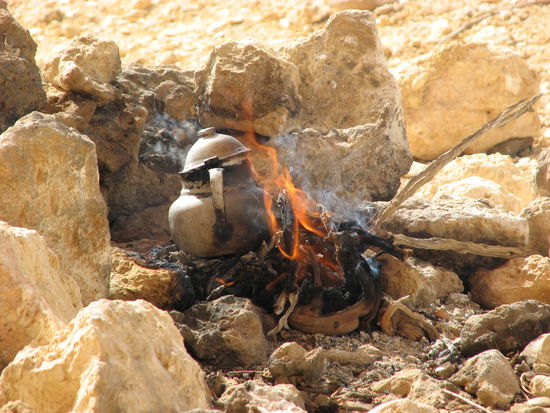 das Teewasser brutzelt auf offenem Feuer