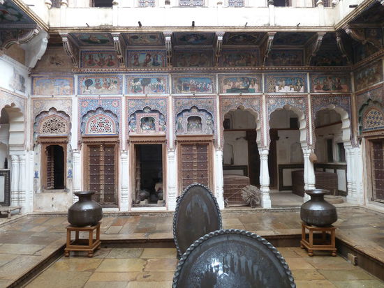 Der Innenhof mit den typischen Arkadenbögen z.T. mit kunstvoll geschnitzten Türen und viel Malerei