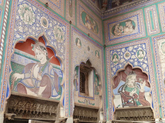viele der Wandgemälde sind noch gut erhalten - andere stark verblichen - im unteren Bildrand sind die kunstvoll gearbeiteten Türstürze zu sehen