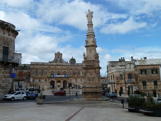 auf der Piazza de la libertà prunkt der 21 m hohe reich verzierte Barockobelisk mit dem hl. Oronzo - im Hintergrund der Palazzo communale