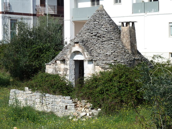 Noch ausserhalb des Stadtviertels - direkt am Parkplatz -liegt ein nicht bewohnter Trullo, der denen ähnelt, die früher einmal anderen als Wohnzwecken diente.