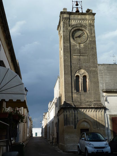 um einen kleinen Marktplatz scharen sich eine Kirche und der Uhrenturm; die geraden Straßen enden bald an der Stadtmauer