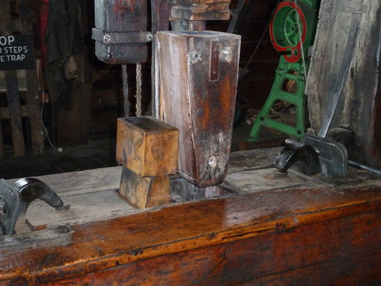 durch eine Hammerpresse ausgepresst wird. Das reine Erdnußöl läuft am Boden in eine Wanne.