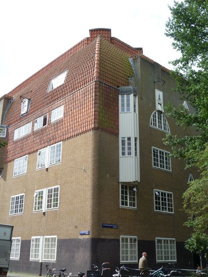 Der zweite Block auf der anderen Seite eines kleinen Parks besticht durch die senkrechte Verwendung von Dachziegeln, die in ein Krüppelwalmdach übergehen