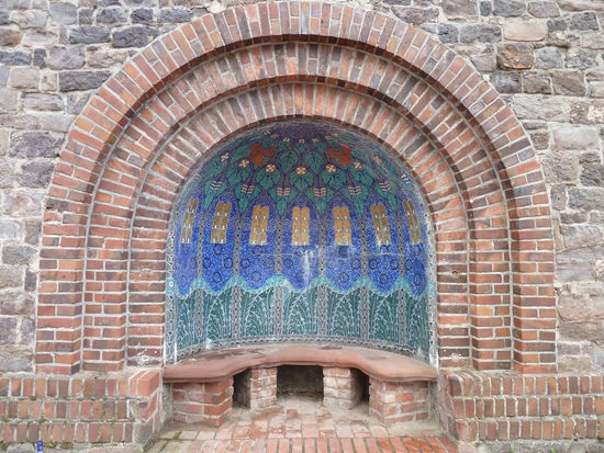 Das etwas versteckt an der unteren Terrasse auf der Gebäuderückseite liegende Brunnenhäuschen hat eine Kuppeldeckung und einfache Vierkantpfeiler in Backstein.
