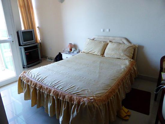 unser einfaches aber sauberes Zimmer - man beachte auch hier die Plastikschlappen am Bett