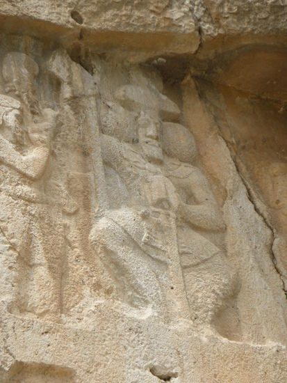 Der Herrscher ist in der Mitte frontal dargestellt, wie er auf einem Thron sitzt.