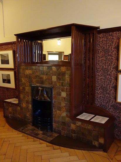 Der gekachelte Kamin mit aufgesetztem holzumrahmtem Spiegel und kupfernem Einsatz stammt aus der ersten Wohnung der Familie im Museum Folkwang.