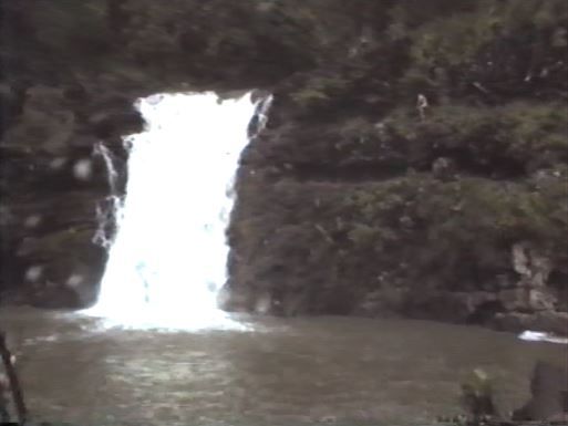 rund um den Wasserfall stehen junge Männer und wagen Kunstsprünge ins Wasser