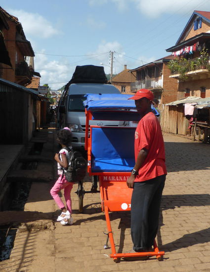 das Bild zeigt aber wohl ein Mädchen aus 'besseren' Kreisen - modernste Kleidung, selbst kleine Schuhe mit Absätzen - Haltestelle vor einer Privatschule - der "Tireur" selbst ist natürlich barfuß