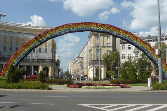 die Wohnblocks um den Platz mit ihren Arkadengängen zeigen Stilelemente der Jahrhundertwende und des sozialistischen Realismus