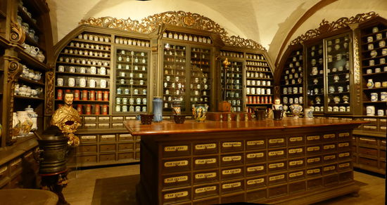 In dieser Offizin wirkte von Anfang an eine Frau, eine Ursulinerin. Wie aber konnte sie der Apothekerkunst nachgehen, wenn Frauen bis zu Beginn des 20. Jh. das Erlernen und Ausüben des Apothekerberufes, wie fast aller anderen Berufe auch, untersagt war? Offensichtlich gab es Ausnahmen von dieser Regelung, sonst hätten in Frauenklöstern wie dem Ursulinenkloster keine Apotheken bestehen können. Üblicherweise erfolgte dort die Ausbildung so, dass eine in der Arzneikunst erfahrene Nonne ihr Wissen an eine Novizin weitergab, diese es an die nächste Generation vermittelte und so fort.
Lehrzeugnisse des 18. Jh. zeigen aber, dass manch eine Frau selbst die reguläre Ausbildung einer öffentlichen Apotheke absolvieren konnte, allerdings nur in Verbindung mit der getroffenen Wahl eines klösterlichen Lebens.