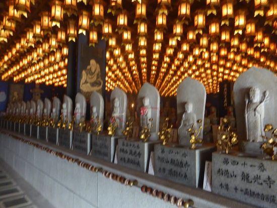 In der dunklen Hen Jyokutsu Höhle befinden sich die Buddha Bilder von 88 Tempeln der Pilgerroute von Shikoku. Die Betenden glauben, dass sie den Menschen genauso helfen, als wenn diese den Pilgerweg gegangen sind.