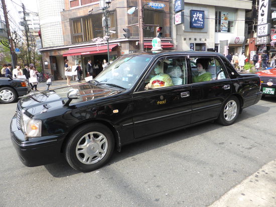 wie Puppen sehen die 'echten' Geishas' aus, die in einer Limousine mit weißbehandschuhtem Chauffeur kutschiert werden