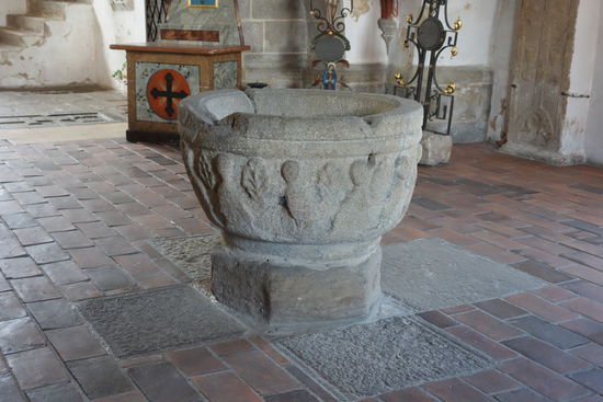 Unter der Empore steht das älteste Ausstattungsstück der Pfarrkirche Maria Himmelfahrt, ein halbkugeliger, romanischer Taufstein. Er ist stark verwittert, da er über lange Zeit auf dem Friedhof Regen und Wind ausgesetzt war. Im Umlauf des Steins sind Christus und die zwölf Apostel zu erkennen, dazwischen verschiedene Pflanzenornamente.