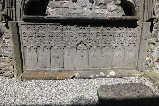 das Grabmal hat neun Tafeln mit Figuren, die von links nach rechts:
St Dominick, Sr Katharina, eine weibliche Heilige (?), die Jungfrau Maria, Die Kreuzigung, St Johannes, Erzengel Michael (mit Schwert und Flügeln), St Peter (mit Schlüssel)» einen Erzbischof repräsentieren