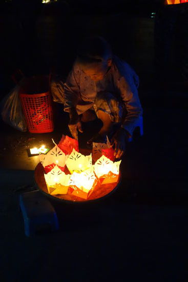 in gefaltenen Papierschiffchen werden abends brennende Teelichter aufs Wasser gesetzt