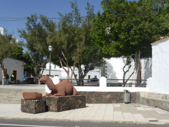 vor der Kirche erinnert ein liegendes Dromedar an die historische Begebenheit vom 13.Oktober 1740 als die Bauern durch eine List mit einer Herde Dromedare als Kugelfang einen Piratenangriff abwehren konnten. .