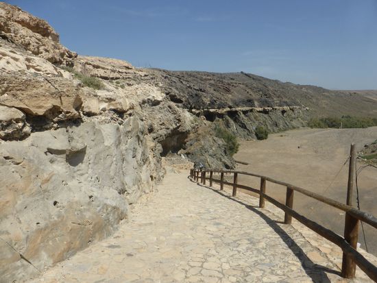 Die Steilwände des trockenen Flußtales sind in verschiedenen Schichten unterscheidbar, die den verschiedenen Erdzeitaltern zuzuordnen sind.
Am Fuße des Pfades steht eine hochinteressante Tafel, die die einzelnen Schichten erläutert: