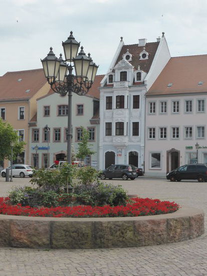Marktsüdseite - Reizvoll ist auch die Südfront des Marktes. Leipziger Kaufmannshäusern nachempfunden wurde Nr. 23, ein Bau von 1734 wie auch das Nachbarhaus Nr. 22. Für Grimma ist es das eindrucksvollste Barockgebäude. Die lange Restaurierung von 1986 bis 1992 sieht man dem Haus mit dem über zwei Etagen reichenden Erker an. Es enthält wertvolle Details aus der Erbauungszeit im Inneren und beherbergt das Fremdenverkehrsamt der Stadt.