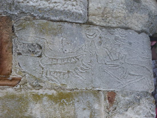 der Stein wurde wohl irrtümlich - auf den Kopf - gedreht in die Mauer eingelasen - u.a. ist ein Minarett zu erkennen (?!)