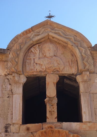 auf dem oberen  von geoemetrischen Mustern gerahmten Portalfeld ist die Dreifaltigkeit Gottes dargestellt