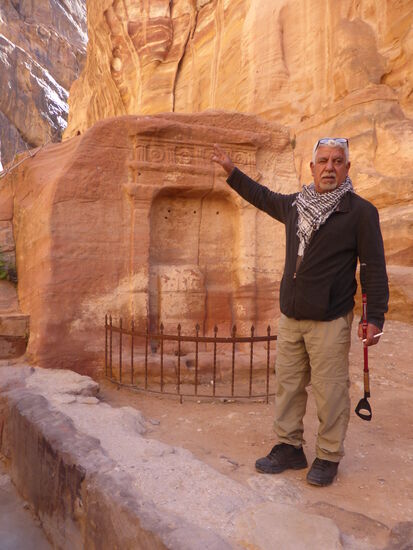 Khalil erläutert den aus dem Fels gehauenen Gedenkstein vor einer kleinen Höhle