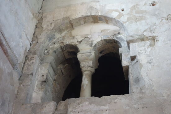 die schwer beschädigte Wand zum Westturmbauwerk erklärt er uns mit jedem erdenkllichen Details - man erkennt mit seiner Hiklfe tatsächlich Reste von Malereien - beispielsweise in der Rundung des Doppelbogens