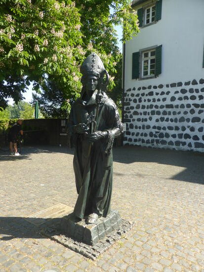 an den Gerichtsbäumen vor dem Rheinturm steht eine Skulptur des Erzbischofs Friedrich von Saarweden