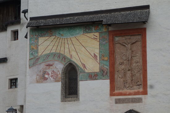 Sonnenuhr und Kreuzigungsrelief, von 1501, aus Adneter Marmor mit lateinischer Inschrift: "d(o)m(inu)s propicius esto michi peccatori" (Der Herr ist mir Sünder gnädig) Zu sehen ist auf dem Relief auch kniend der Erzbischof als Stifter der Kirche.