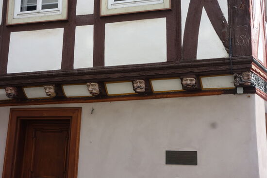 die in die Balkenköpfe geschnitzten Figuren stellen die Hoffahrt, den Geiz, den Neid, die Unkeuschheit, die Unmäßigkeit, den Zorn und die Trägheit dar