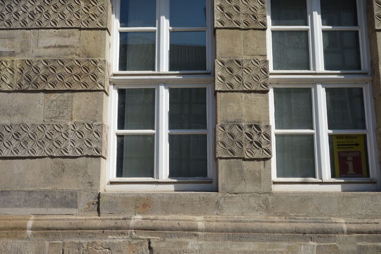 endlos umlaufende Quaderverzierungen die mit glatten Bändern  abwechseln zwischen allen Fenstern