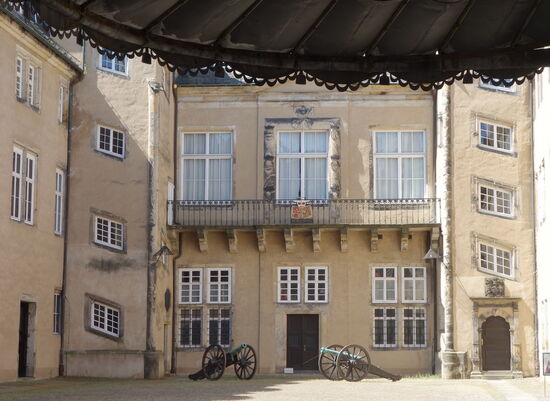 lediglich ein Blick in den Innenhof zeigt die beiden Treppentürme - dazwischen eine Balustrade sowie ein Portal