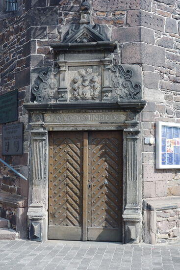 das pilastergerahmte Portal mit Ädikulaaufsatz ist mit 1613 bezeichnet, das Türblatt ist von 1693