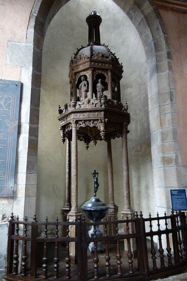 Taufbecken mit einem sechseckigen hölzernen Baldachin aus dem Jahr 1660 - die Kuppel des Baldachins ist mit Statuetten verziert