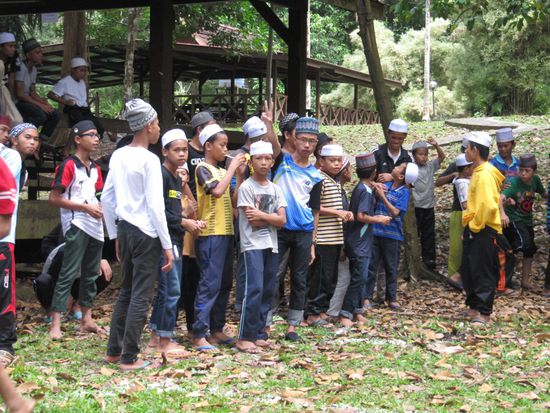 Jungendgruppen: Die Jungs machen Spielchen, die Mädels in Kopftüchern sorgen fürs Essen.