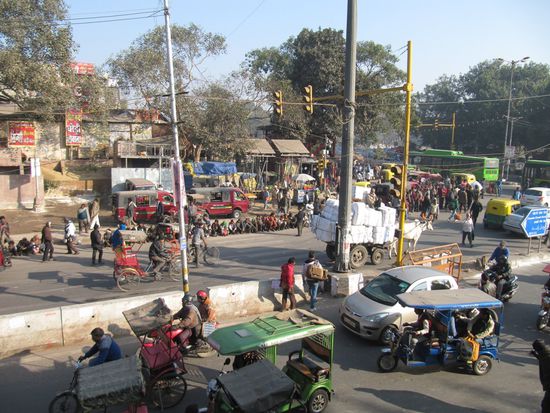 Eine Straßenkreuzung in Agra. Die ärmere Bevölkerung (im Hintergrund) wird mit Essen versorgt.