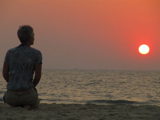 Glutrot und voll geht die Sonne unter.